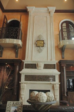 Decorative carved stone fireplace over mantel surround