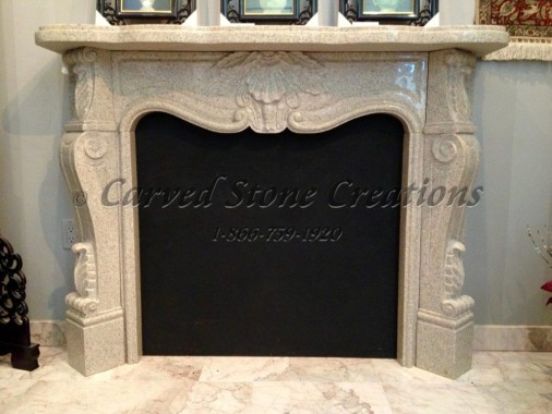 Carved polished granite French country fireplace mantel